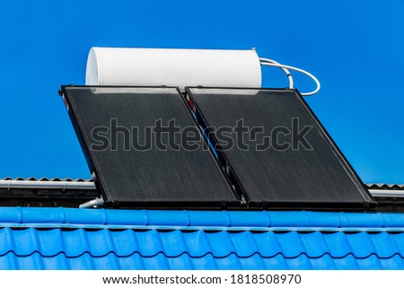 Solar water heater on the roof of a building against the background of the sky. Using solar energy to heat water