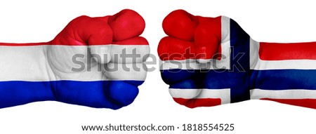 The concept of the struggle of peoples. Two hands are clenched into fists and are located opposite each other. Hands painted in the colors of the flags of the countries. France vs Norway