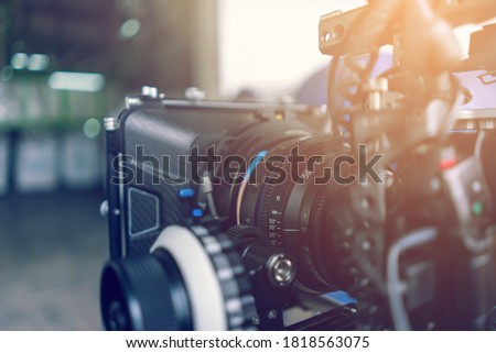 Closeup professional cinema lens behind the scene. Video production equipment.