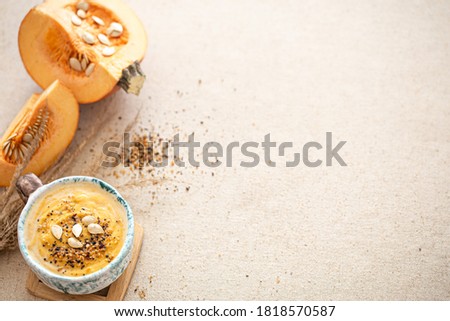 Delicious composition with pumpkin soup in a beautiful ceramic dish. The view from the top. Seasonal food.
