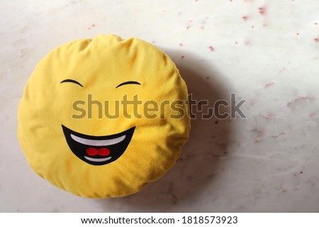 A smiling face, smiling pillow on white marbel background