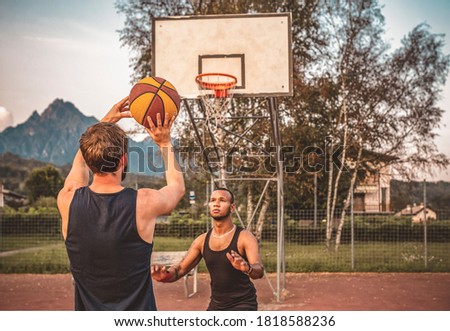 Two friends play basketball on an outdoor court. Young basketball players. sport, leisure