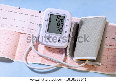 White electric tonometer on a Cardiogram and high pressure value. Medicine concept. Royalty-Free Stock Photo #1818588341