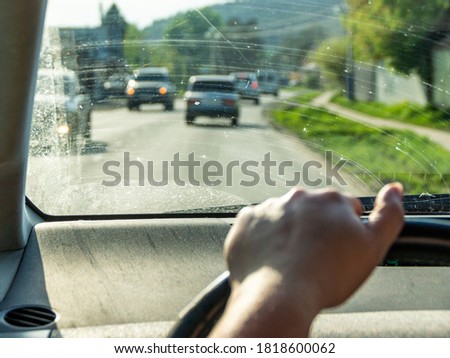 view from behind the wheel of a dirty windshield, selective focus