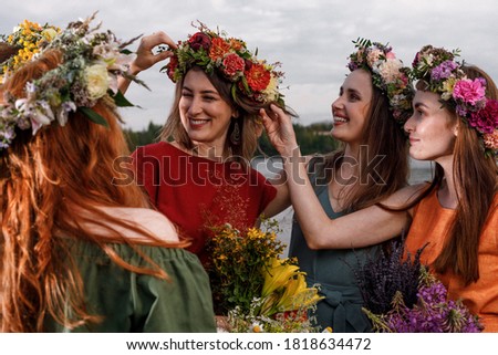 Lovely women's in flower wreaths in nature. Ancient pagan origin celebration concept. Summer solstice day. Mid summer. Royalty-Free Stock Photo #1818634472