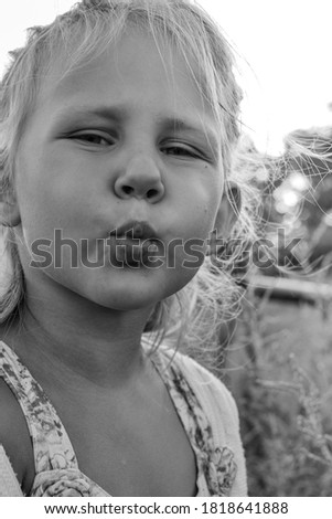 Close up black and white portrait of cute adorable smiling caucasian child. Portrait of a happy child in nature. Happy childhood concept. The baby looks into the camera.