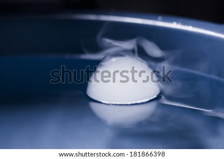 Abstract shot with big soap bubbles on a water surface with smoke inside. Image has grain texture visible on its maximum size 