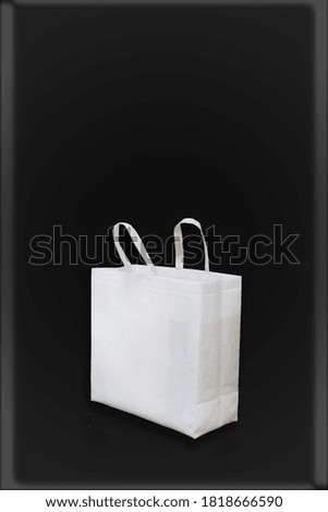 Photo white color tote material bag. Empty concrete black painted wall chalkboard background. space for your business message. Horizontal mockup. 3D rendering