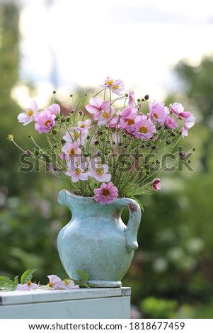 Bouquet of flowers in ceramic pitcher, daylight, scene in garden, vintage style