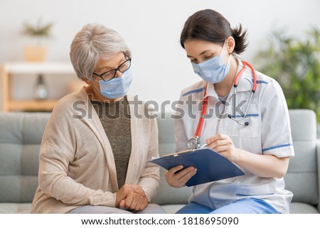 Doctor and senior woman wearing facemasks during coronavirus and flu outbreak. Virus protection. COVID-2019. Taking on masks. Royalty-Free Stock Photo #1818695090