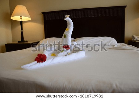 hotel bed, a figurine of a towel on a bed in a hotel