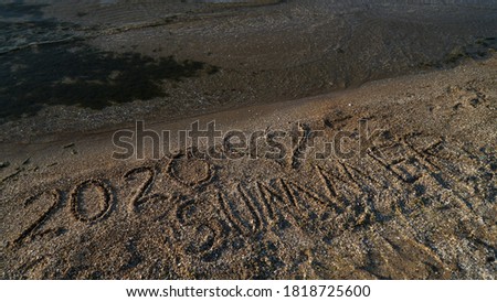 The inscription on the sand in the sea summer 2020 and heart
