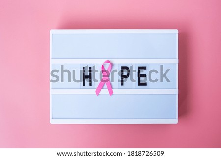 October Breast Cancer Awareness month, Pink Ribbon on lightbox with HOPE text background for supporting people living and illness. International Women, Mother and World cancer day concept