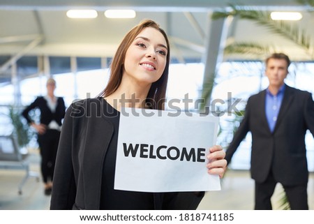 Woman holds welcome sign to welcome travelers at the airport