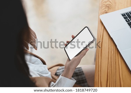 Cropped image of hands are using an empty screen smartphone in the office.