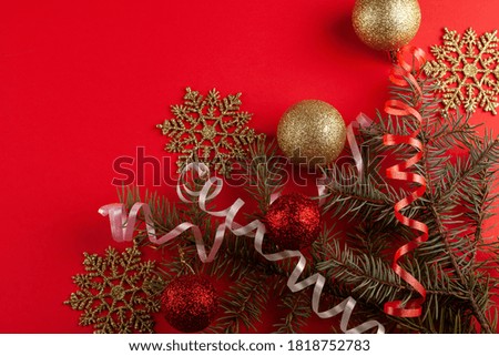 Christmas composition. Fir tree branches, red decorations on red background. Christmas, winter, new year concept. Flat lay, top view, copy space