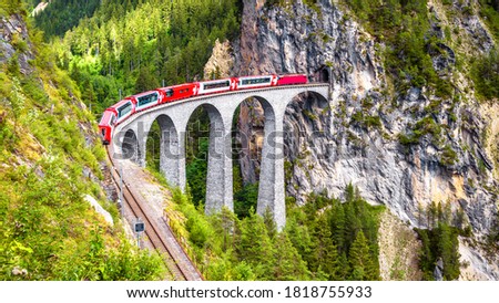 Bernina express on Landwasser Viaduct, Switzerland. It is landmark of Swiss Alps. Nice Alpine landscape in summer. Red glacier train on railroad bridge in mountains. Scenic panoramic view of railway. Royalty-Free Stock Photo #1818755933