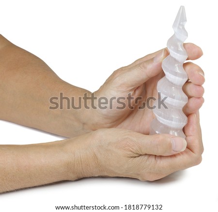 Holding a Selenite Spiral Wand - female hands holding beautiful  carved selenite spiral wand in both hands isolated on white background
 Royalty-Free Stock Photo #1818779132