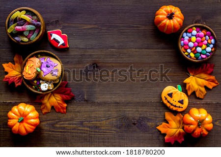 Frame of Halloween pumpkins, cookies and candies, top view