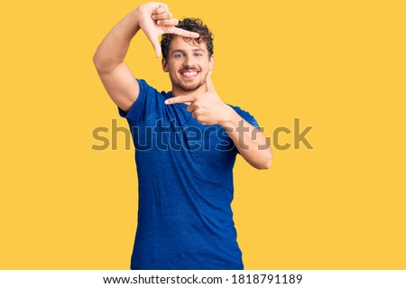Young handsome man with curly hair wearing casual clothes smiling making frame with hands and fingers with happy face. creativity and photography concept. 