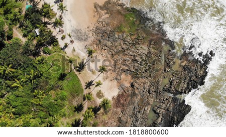 A drone photography from the beach in Itacaré city, Bahia, Brazil. Perfect combination of palm trees, sand, rocks and the ocean.