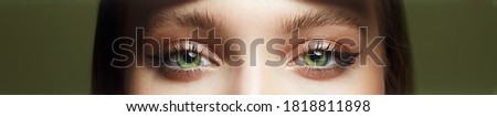 close-up photo of beautiful female green eyes. Part of face with make-up