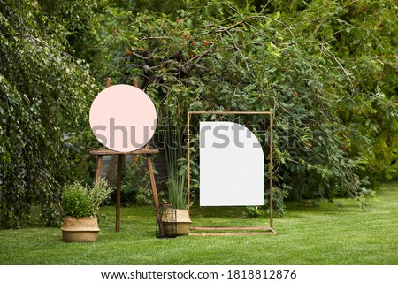empty board stands on green lawn on wedding. invitation for guests for summer wedding ceremony
