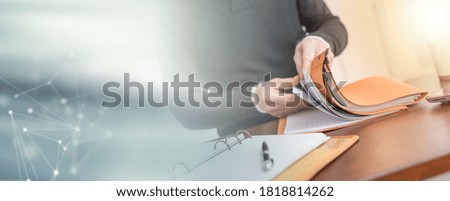 Businessman looking for document in folder at office; panoramic banner