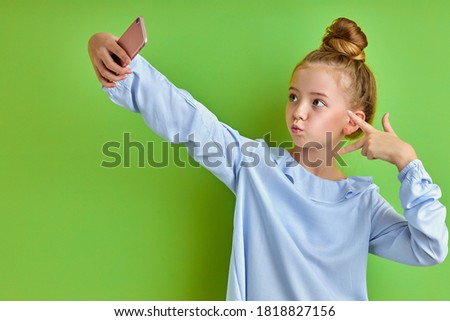 emotional crazy little girl take photo on phone, alone. beautiful kid girl make selfie, posing