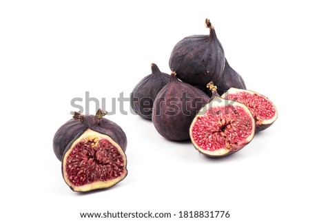 Whole and cut purple figs on white background. Ripe fig fruit.