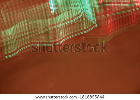 Shapes created by light paints in red and green on a smoky orange background