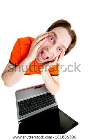 A young man sitting in front of a laptop, isolated on white 