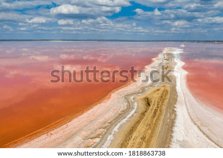 view to sand spit on the pink lake under clouds in summer day with copy space