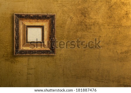 Golden background. Vintage picture frame on gold wall.