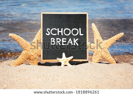 Small black chalkboard with text School Break and starfishes on beach. Seasonal holidays 