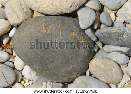inscription 'I love you' written with yellow chalk on a pebble