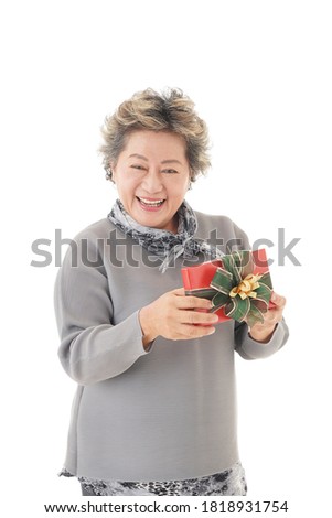 happy asian old woman smiling and holding red box gift on white background.