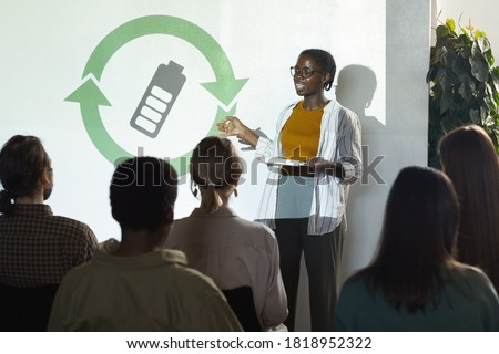 Portrait of young African-American woman giving speech on renewable energy during recycling and waste management conference, copy space