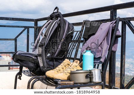 Trecking or hiking equipment - bagpack, boots, socks, pants, folding knife, water flask, kettle pot and flashlight. Outdoor activity concept. Still life close up stock photo.