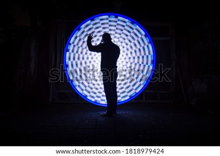 One people standing alone against a incredible circle light painting as the backdrop