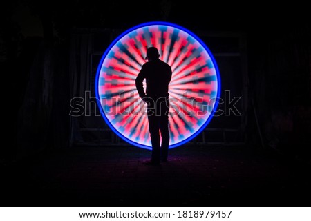 One people standing alone against a incredible circle light painting as the backdrop