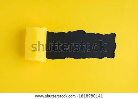 Top above overhead view photo of torn bright yellow paper over black background with copyspace