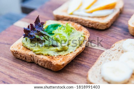 Toast bread with different assortments or tops such as tuna, corn, apple, yogurt, banana, avogado paste and vegetables. Picture is partly focused.
