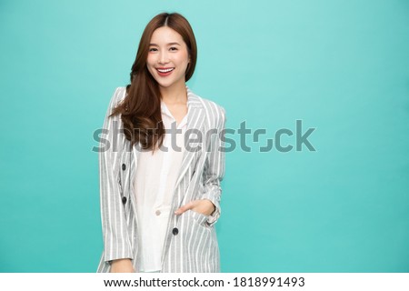 Portrait of successful business asian woman in suit and smile isolated over green background, Young businesswoman smiling and looking at camera, Happy feeling concept