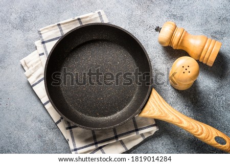 Frying pan or skillet with stone nonstick coating on light stone table. Top view with copy space. Royalty-Free Stock Photo #1819014284