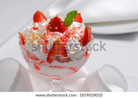 Strawberry dessert with whipped cream and ground nut.