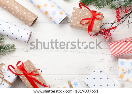 Christmas gift boxes packaging, paper rools, decor and fir tree. Top view flat lay with copy space