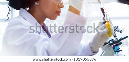 Scientist / researcher team conducting scientific research in science lab. African female scientist / researcher working on R&D project for bio chemistry. African scientist in hospital lab concept.  Royalty-Free Stock Photo #1819055876