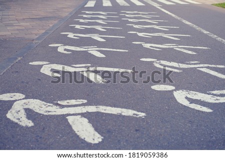 Pedestrian crosswalk with drawings of a man on the asphalt