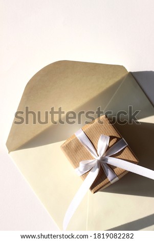 Overhead of Decorated Gift Box on Kraft Envelope. Holiday Design Concept with Copy Space.